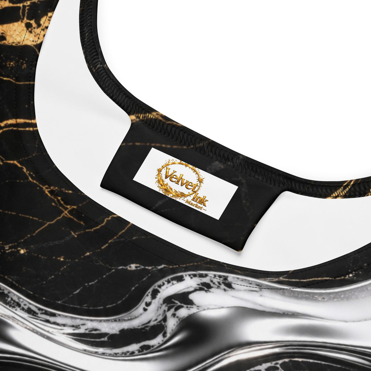 Close-up of a black and gold marble-patterned garment with a white inner lining and a sewn-on brand label reading Velvet Ink.