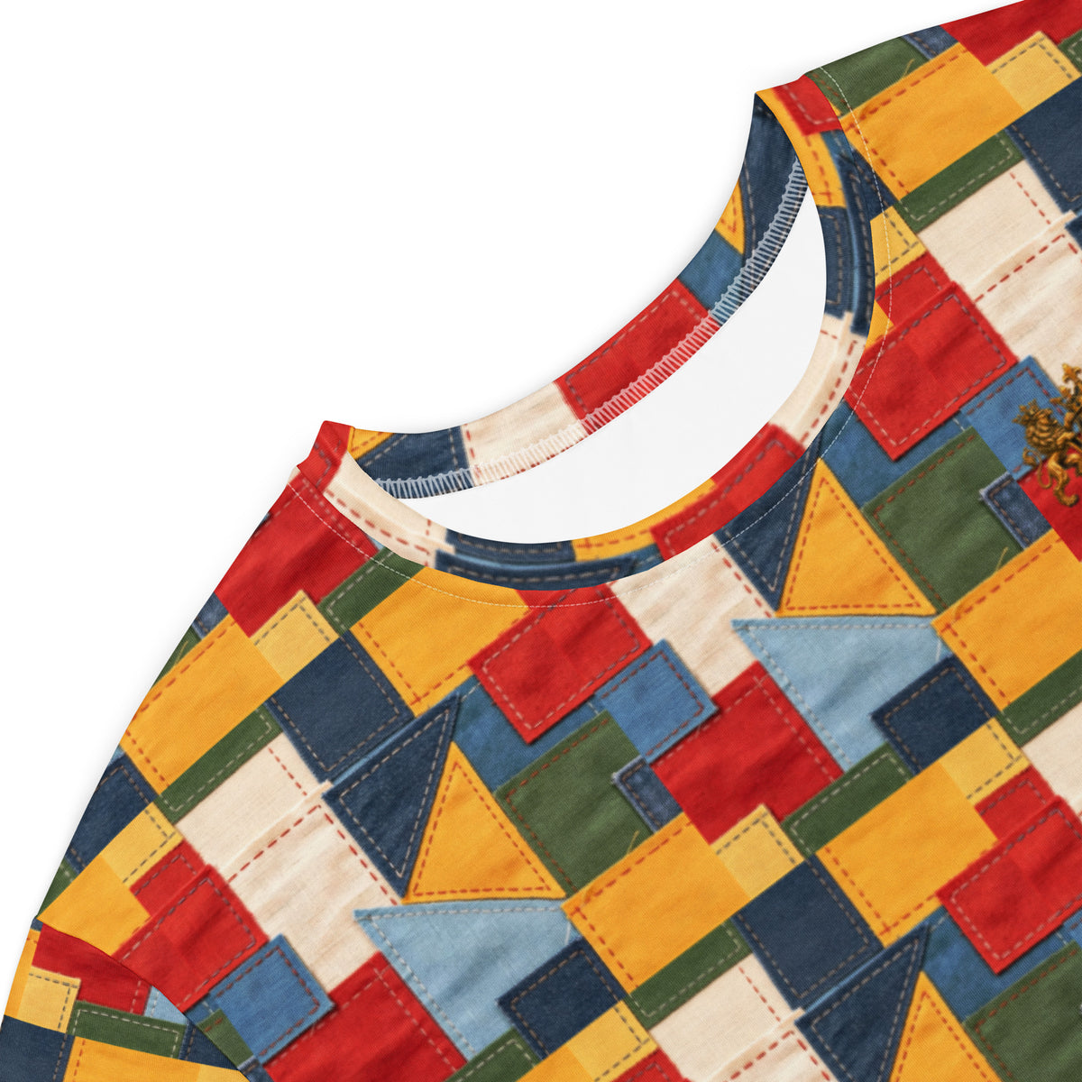 Close-up of a colorful geometric patchwork-patterned garment, showing a crew neck with a white inner lining and a multicolor fabric body made of stitched rectangular and triangular panels in red, yellow, blue, green, and cream on a white background.